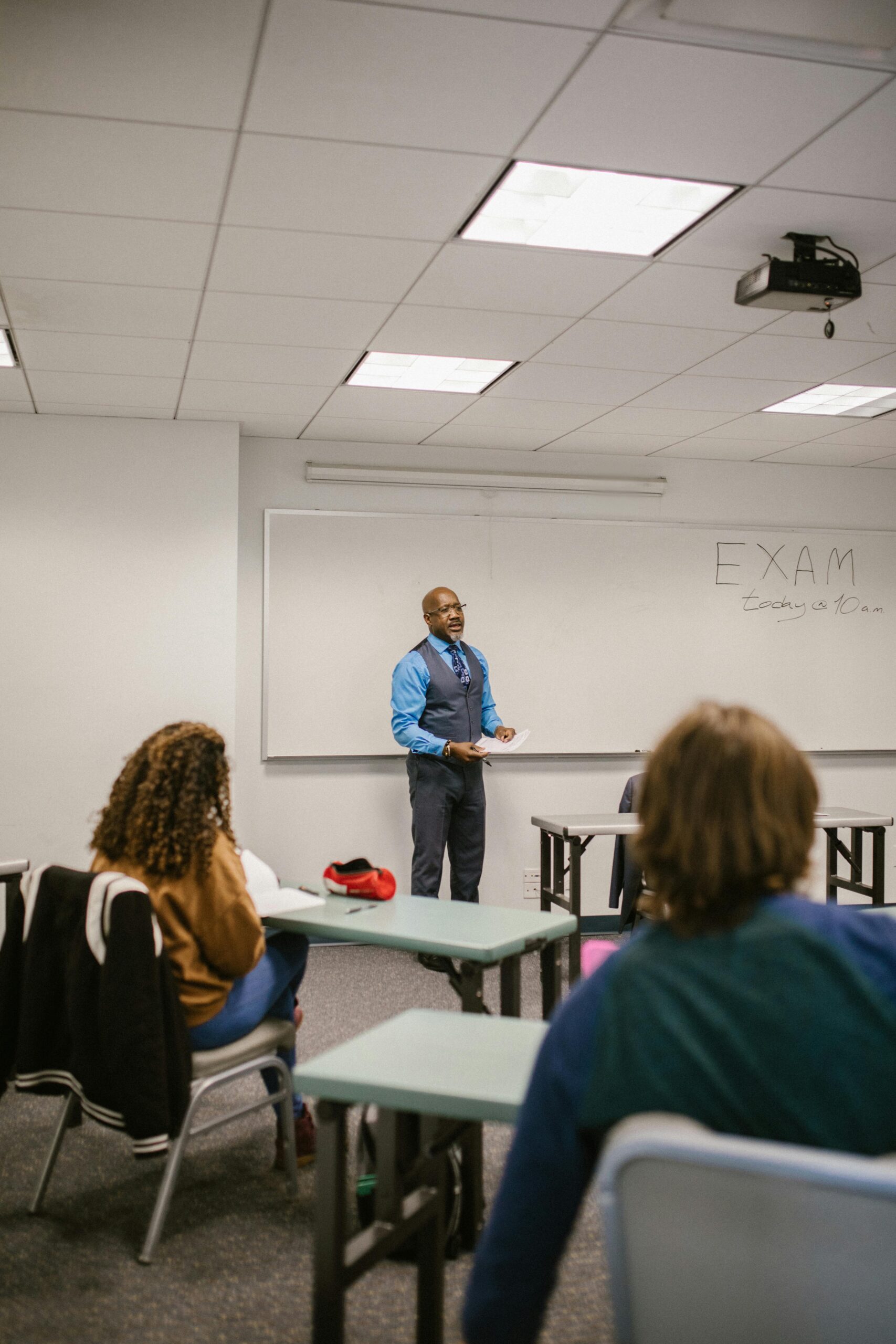 Professor giving a lecture to diverse students in a university classroom setting.